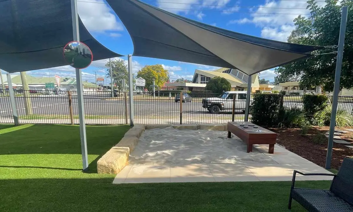 New sandpit and timber bench under a shade sail, Dalby childcare centre yard upgrade