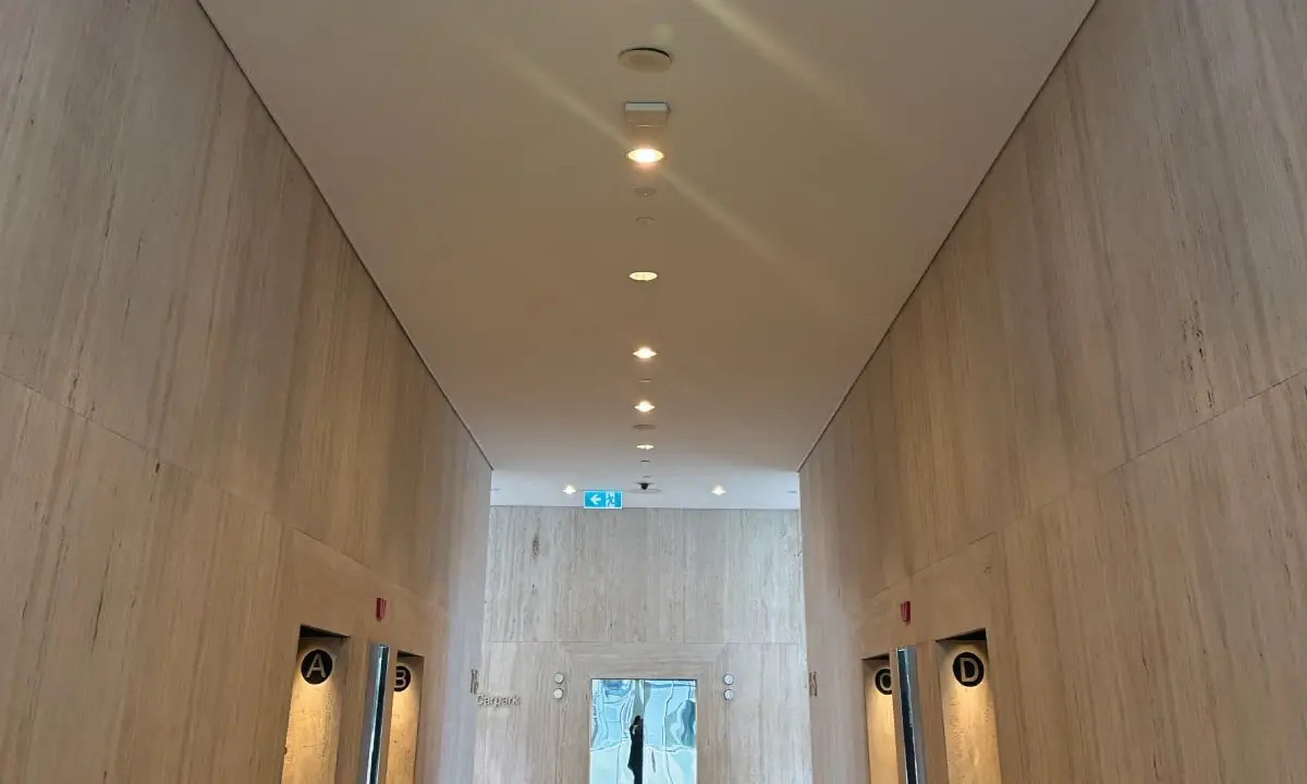 Lift lobby with timber-look wall panels and finished ceiling after the upgrade, Eagle Street, Brisbane