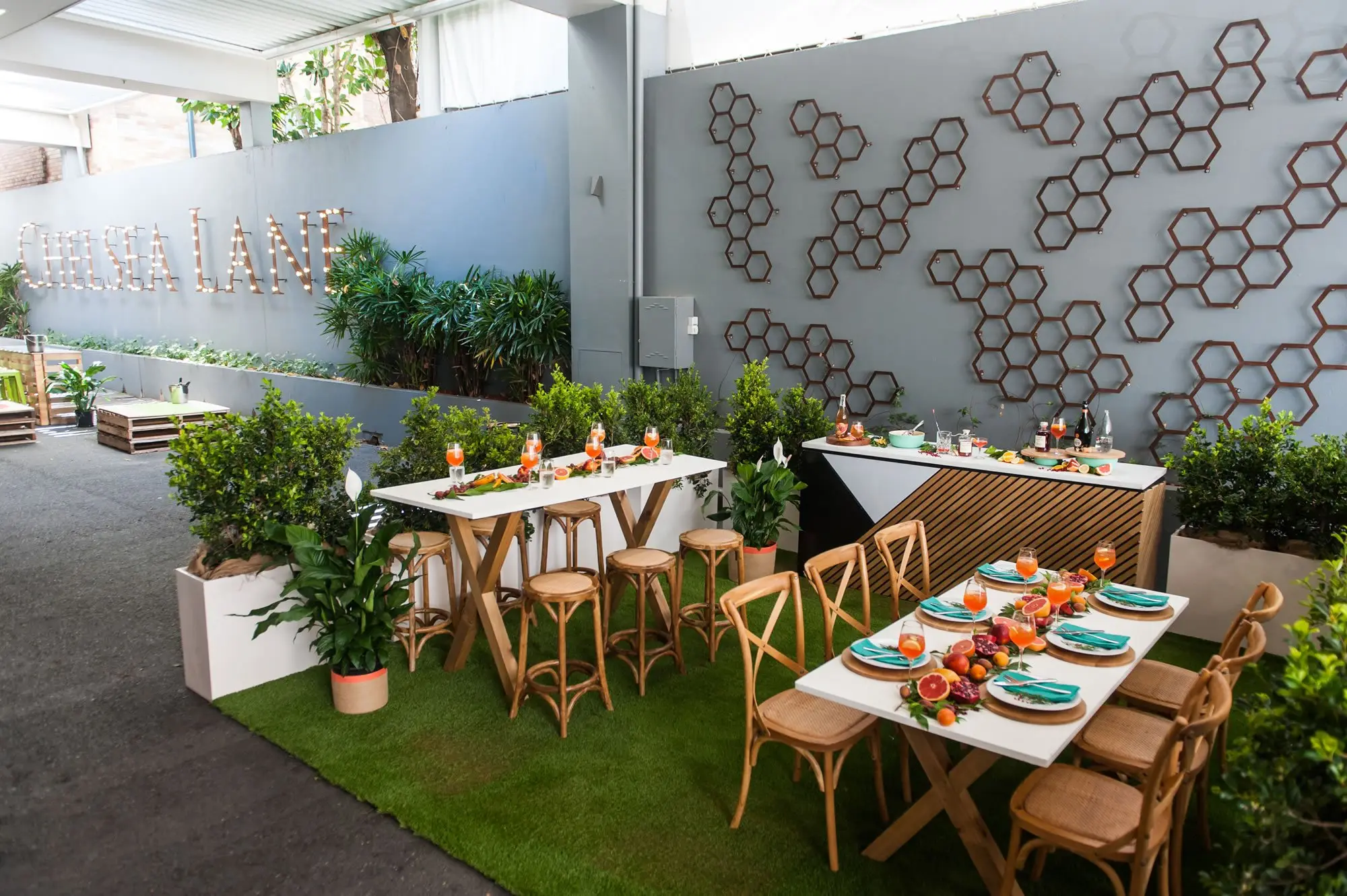 Chelsea Lane at the Mercure Brisbane with lit marquee lettering, hexagon wall art and timber function tables