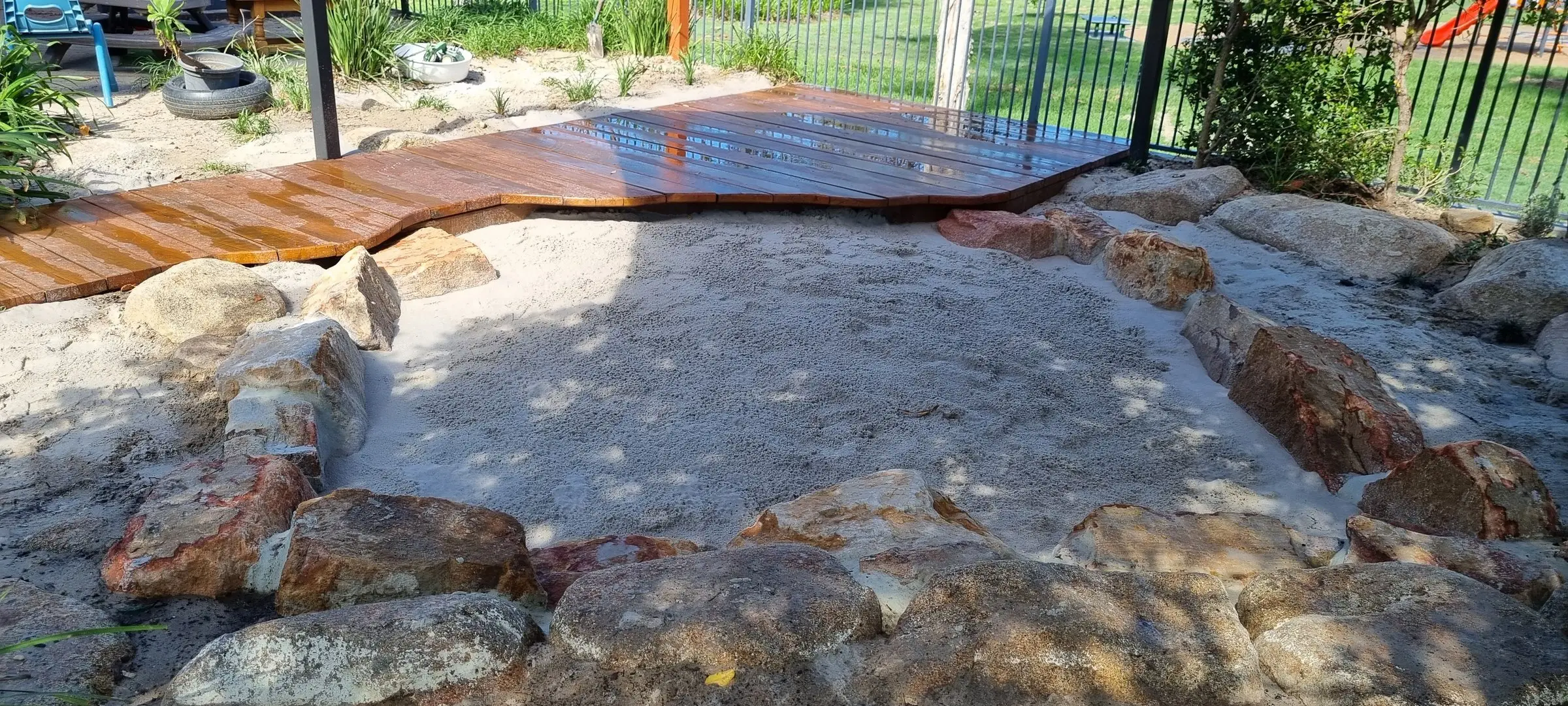 New timber deck and sandstone creek bed in a childcare nature play yard