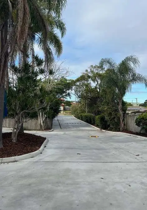 New concrete driveway between palm trees at a childcare centre
