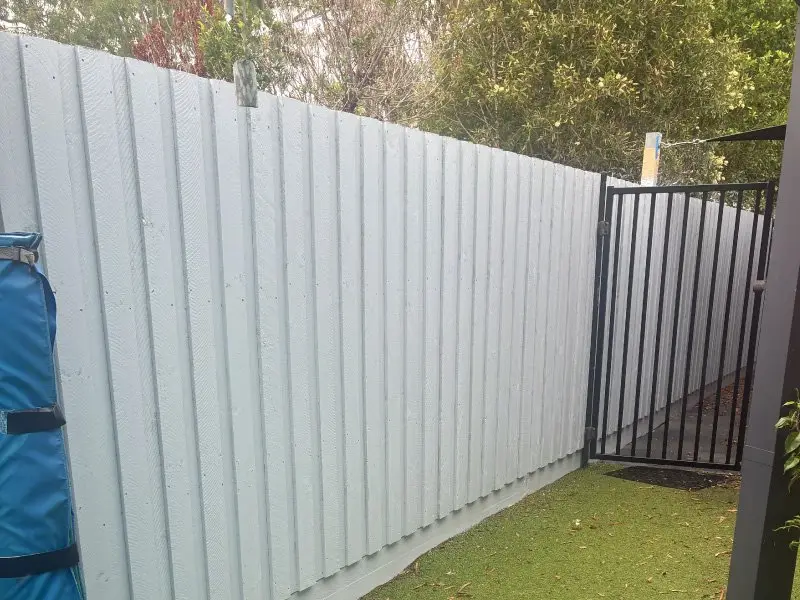 New fence and pedestrian gate beside the synthetic grass yard