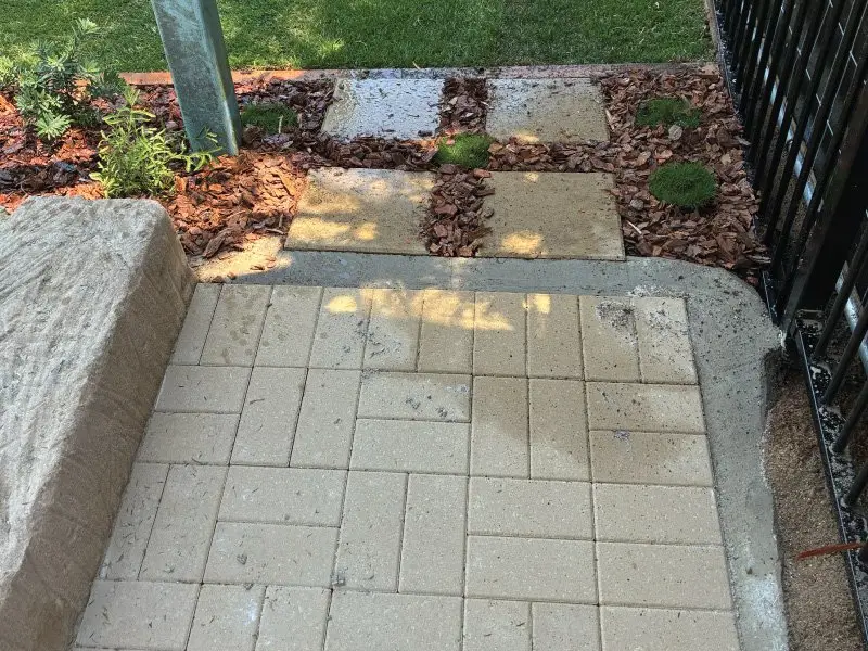 New paving meeting synthetic turf and garden bed