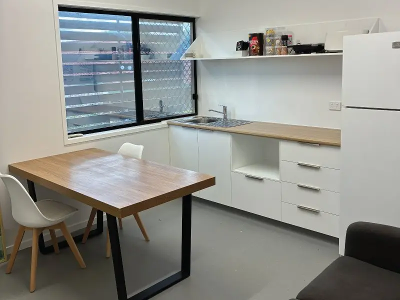 New staff room with timber table and white kitchenette