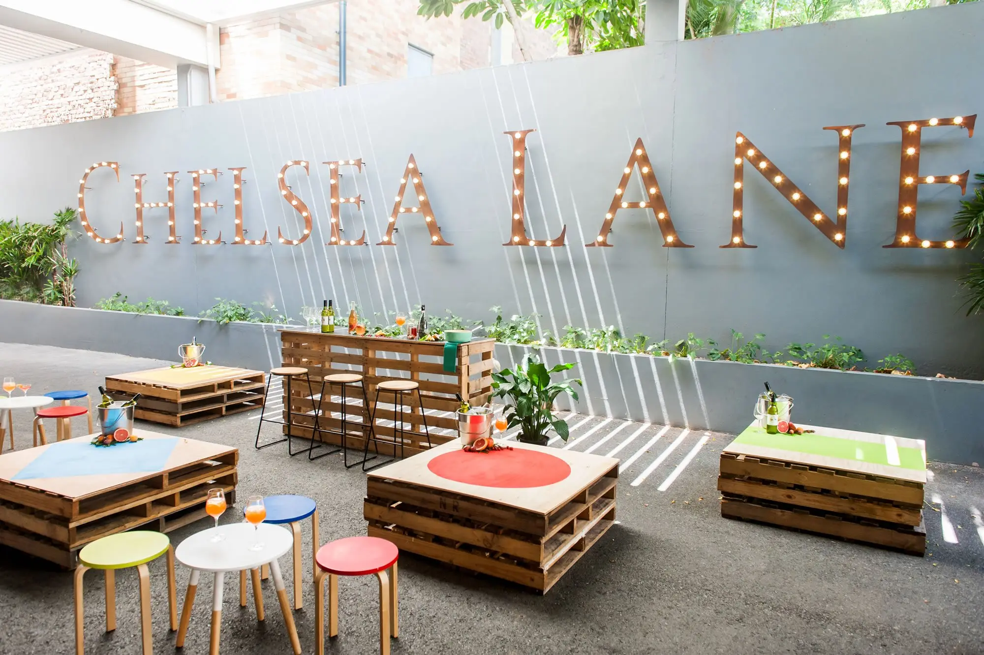 Chelsea Lane lettering above pallet seating and planters