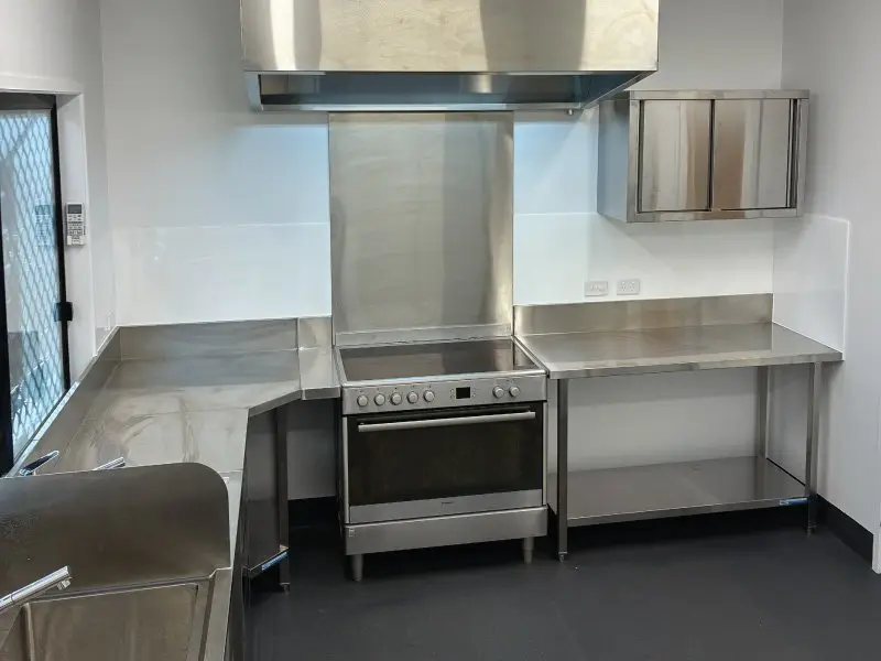 Range hood and commercial oven with stainless steel splashback