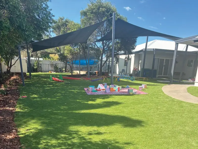 Shade sail over the new synthetic turf yard with soft play blocks