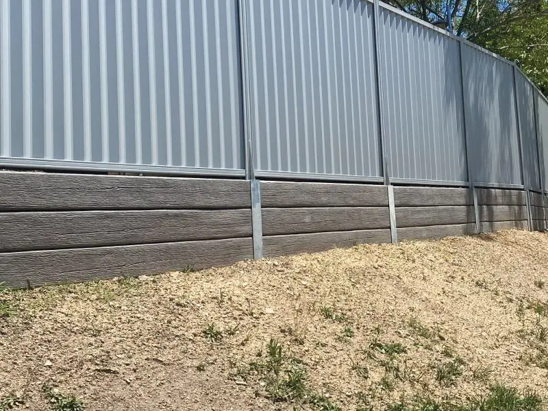 Finished retaining wall and fence seen from the yard