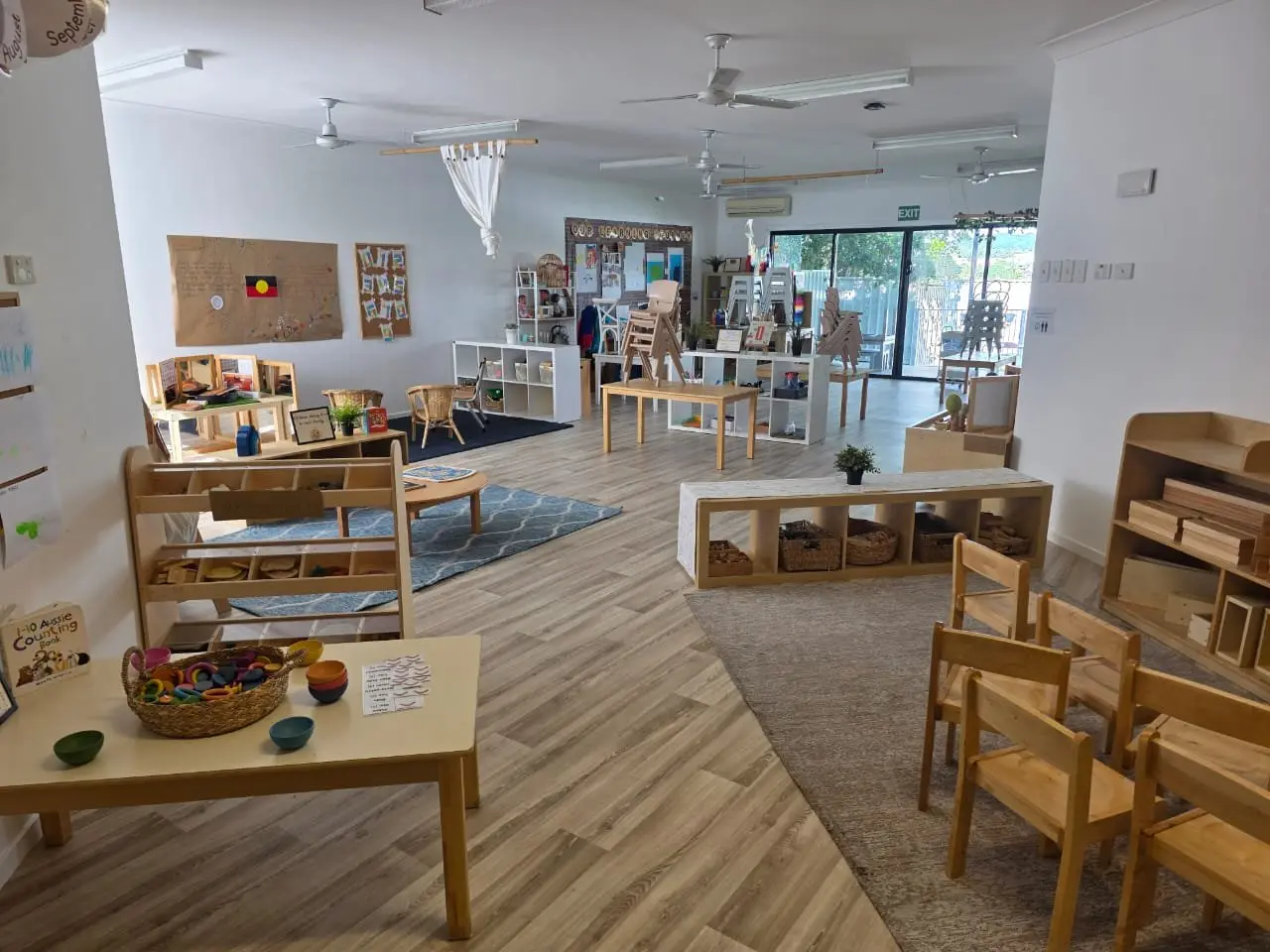 Bright refurbished playroom with low shelving and timber furniture