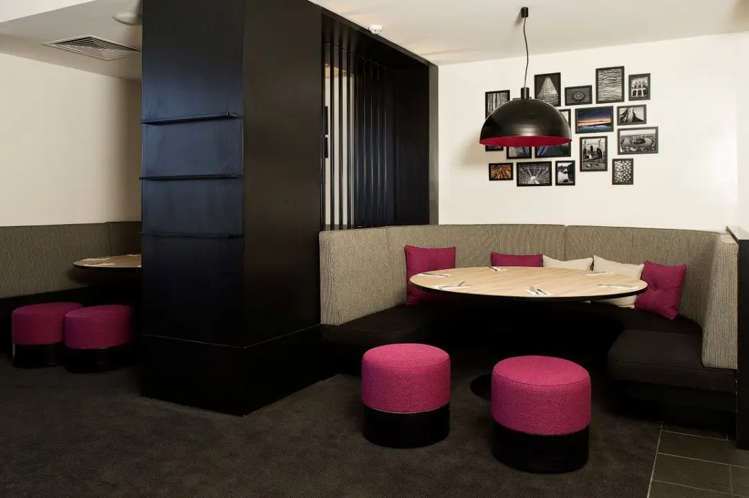 Booth seating with pink stools and a feature pendant