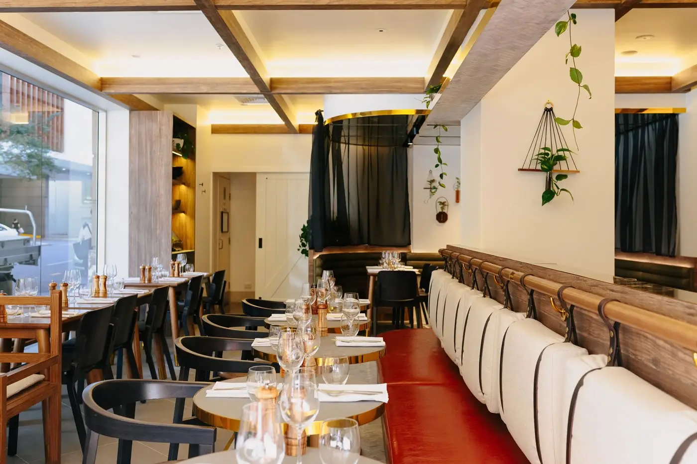Refurbished Croft House dining room with red leather banquette and timber rafters, The Sebel Brisbane