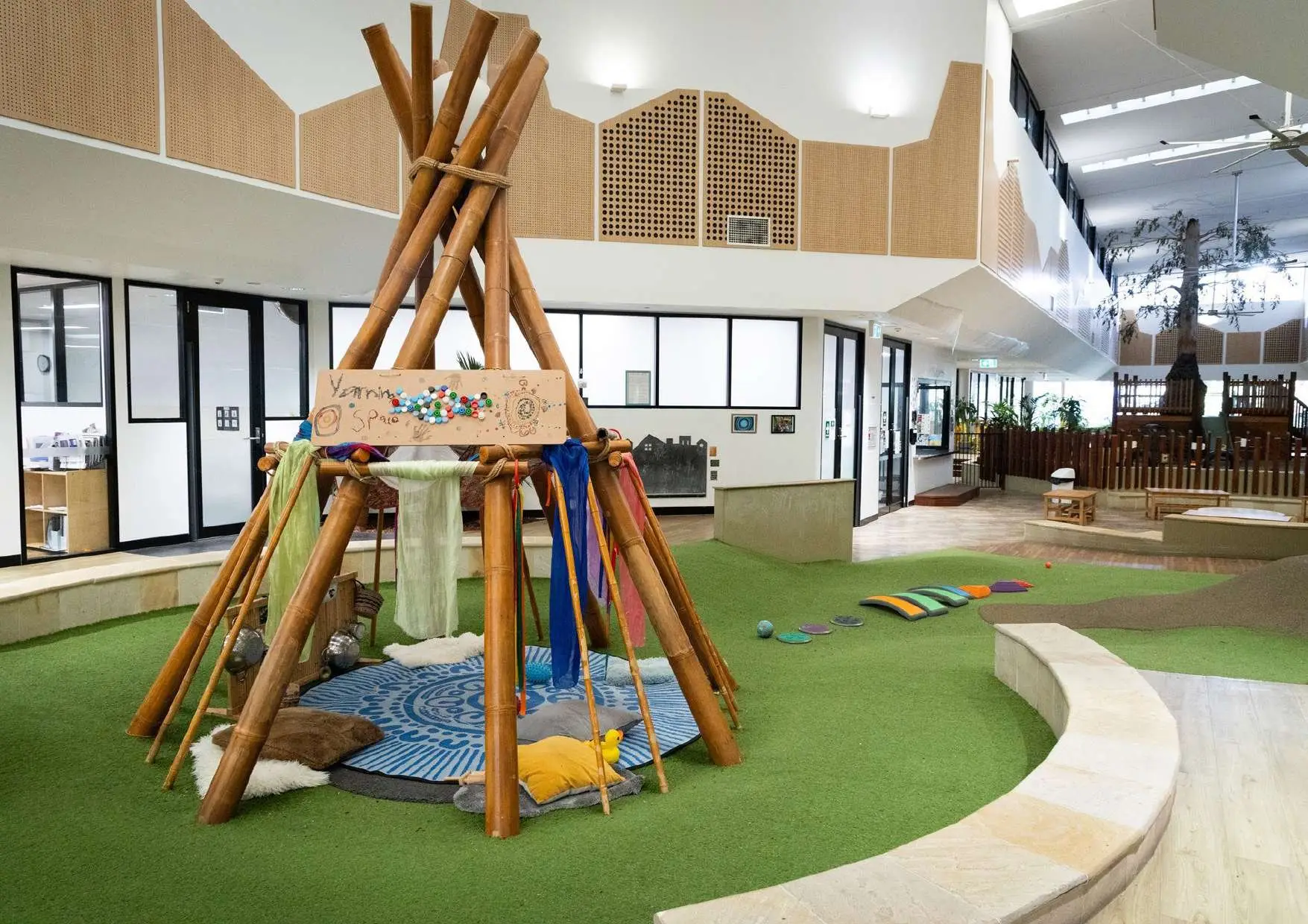 Refurbished indoor playroom with a timber teepee and soft play surfaces